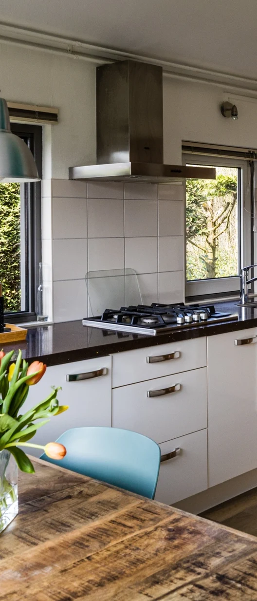 Moderne keuken met een houten tafel en een boeket tulpen op de tafel.